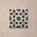 Azulejo porcelánico individual de estilo marroquí Agraba Tanane 20x20 cm con patrón geométrico de estrellas y cruces en verde intenso, rosa suave, blanco y tonos tierra, con acabado mate liso.