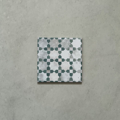 Azulejo individual de estilo marroquí Bedouin Mequinez Verde 15x15 cm con patrón tradicional geométrico de estrellas y cruces en verde, blanco y gris suave, con efecto envejecido y acabado de inspiración artesanal.