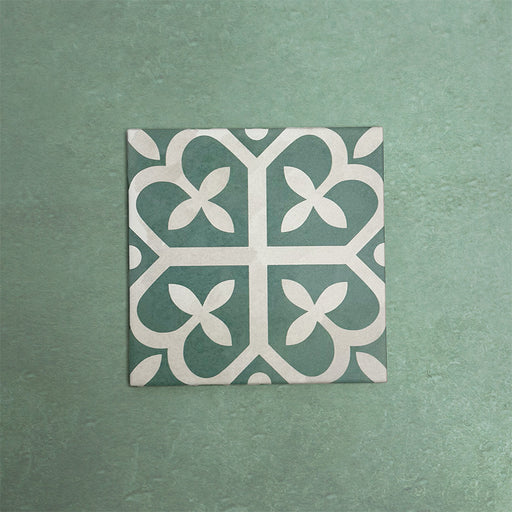 Baldosa cerámica Iris Verde 20x20 cm de estilo Victoriano Marroquí con patrón geométrico en verde suave y crema, ideal para aportar interés decorativo a suelos y paredes en interiores clásicos y contemporáneos.