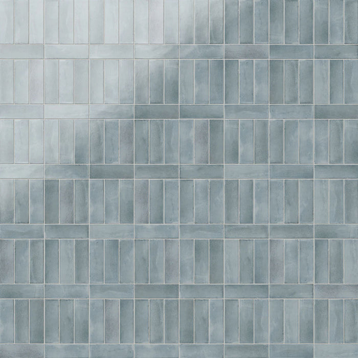 Azulejos de pared Atlas Blue Mini Brick 5x15 cm en acabado brillo, mostrados en múltiples opciones de colocación como ladrillo, lineal, vertical, decorativo y en espiga, con tonos azules suaves, sutil variación tonal y un efecto artesanal.
