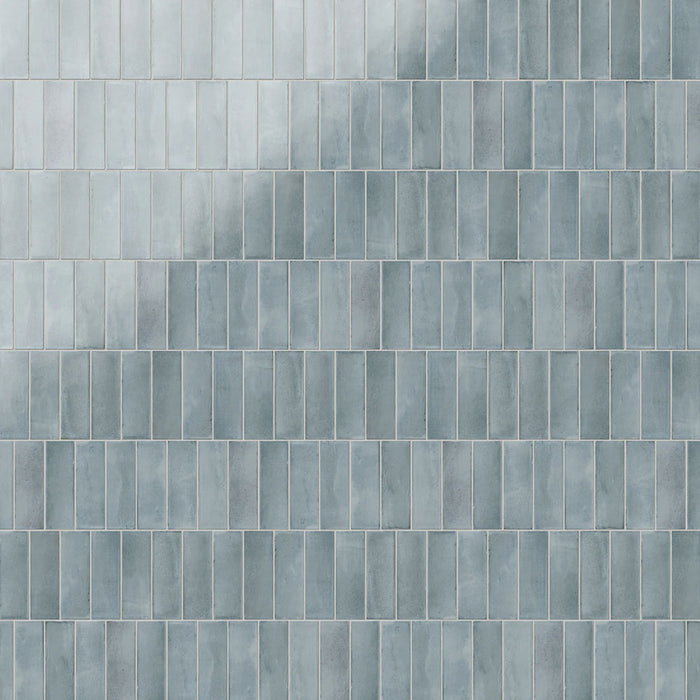 Azulejos de pared Atlas Blue Mini Brick 5x15 cm en acabado brillo, mostrados en múltiples opciones de colocación como ladrillo, lineal, vertical, decorativo y en espiga, con tonos azules suaves, sutil variación tonal y un efecto artesanal.