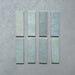 Vista cenital de azulejos de pared cerámicos Zellij Aqua Ladrillo 6,5 × 20 cm de estilo marroquí, presentados como piezas individuales, mostrando la suave variación tonal azul verdosa, el acabado brillante artesanal y los bordes ligeramente irregulares para un aspecto auténtico y lleno de carácter.