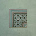 Single Europa Toulouse Corner 20x20cm Victorian Moroccan style tile displayed against a textured green background, featuring a decorative corner border design in green, grey and cream tones.