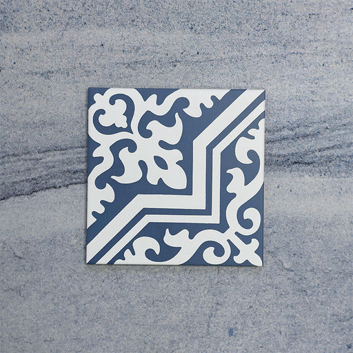 Baldosa Europa Trondheim Blue 20 × 20 cm de estilo Victoriano Marroquí mostrada individualmente sobre un fondo gris texturizado, con un patrón geométrico y floral decorativo en tonos azul y blanco en una imagen de producto en primer plano.