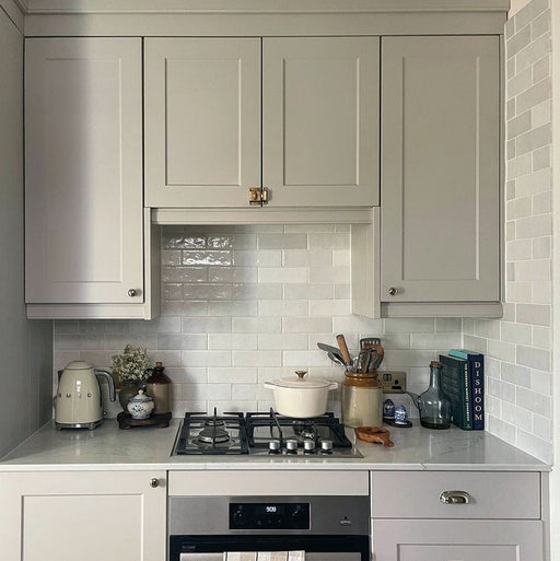 Cocina tradicional con azulejos de pared cerámicos Zellij White Brick 6,5 × 20 cm de estilo marroquí, mostrando una suave variación tonal y una textura brillante de aspecto artesanal, combinados con mobiliario estilo shaker, encimeras con efecto mármol y decoración en tonos neutros.