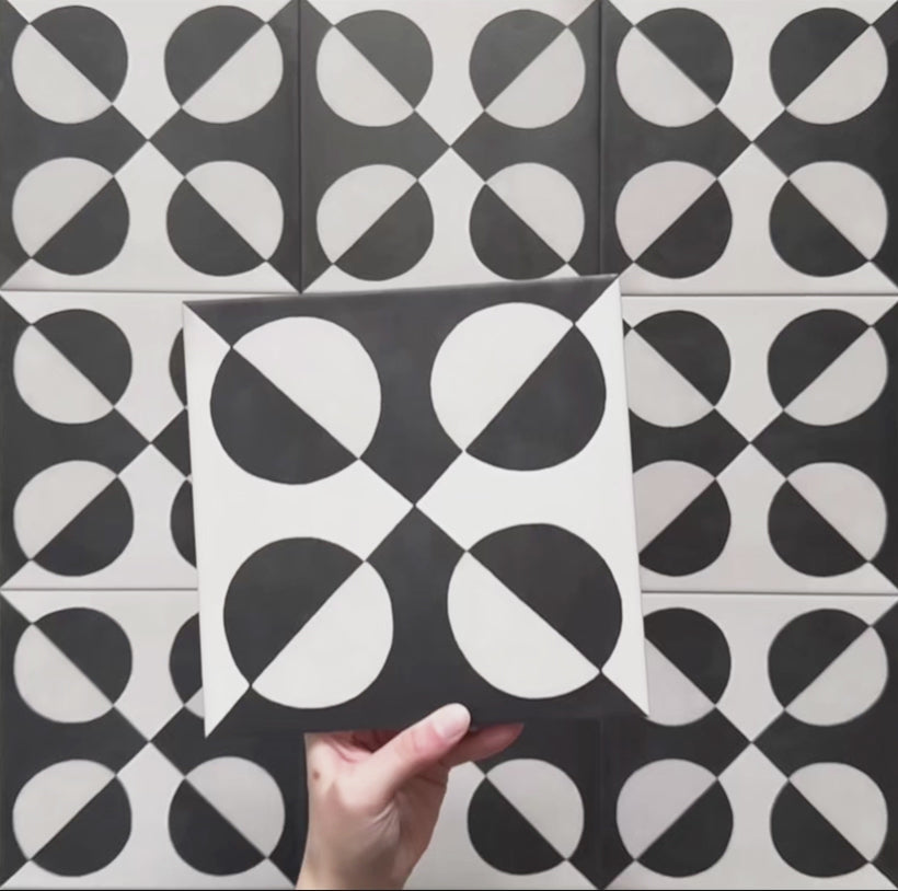 Geometry Illusion Noir 20x20cm geometric patterned tile with black and cream semicircles arranged in a bold symmetrical motif.
