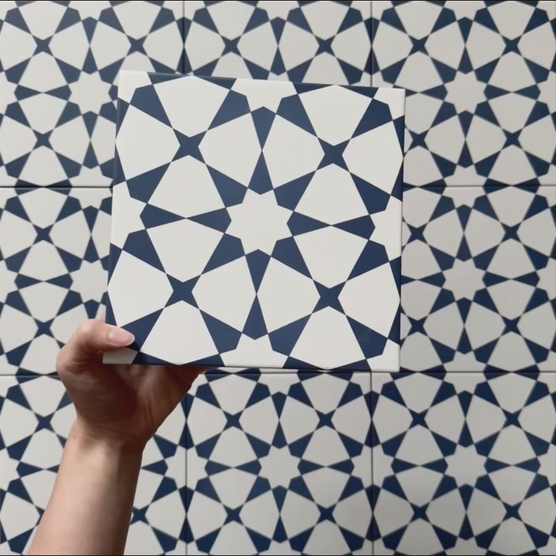 Vídeo de los azulejos cerámicos de estilo marroquí Agraba Azul Marino 20x20 cm, resaltando su marcado patrón geométrico en azul marino y blanco con acabado mate suave bajo luz natural.