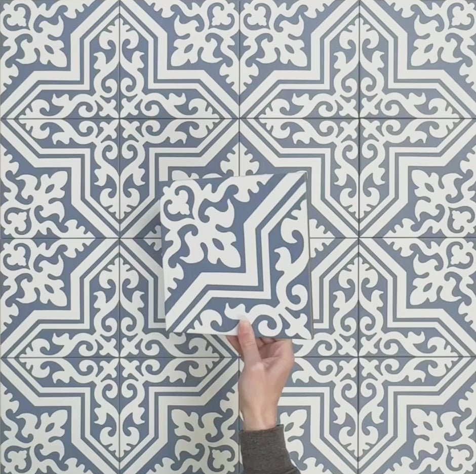 Vídeo que muestra las baldosas Europa Trondheim Blue 20 × 20 cm de estilo Victoriano Marroquí dispuestas juntas, destacando el patrón decorativo repetitivo en tonos azul y blanco, sobre un fondo gris texturizado.