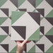 Geometry Angles Patterned Tile in 20cm x 20cm, featuring a modern geometric design with green, white, and black triangular shapes arranged to form a diamond motif.