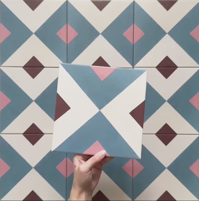 Cabana Guazzatto 20x20cm Moroccan-style porcelain tile featuring a bold geometric cross design in blue, cream, pink, and burgundy shades with a smooth matt finish.