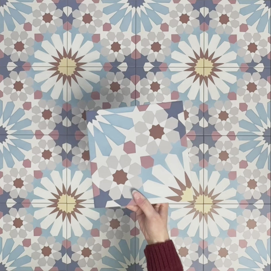 Single Fizaan Fiera 20x20cm Moroccan-style porcelain tile featuring a bold geometric pattern in soft blue, red and neutral tones.