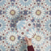 Single Fizaan Fiera 20x20cm Moroccan-style porcelain tile featuring a bold geometric pattern in soft blue, red and neutral tones.
