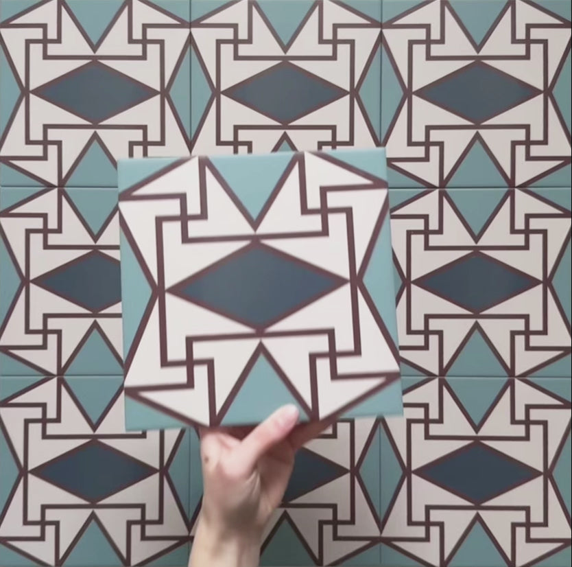 Geometry Iris 20x20cm patterned tile with a detailed geometric motif in teal, navy, terracotta-red, and cream.