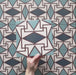 Geometry Iris 20x20cm patterned tile with a detailed geometric motif in teal, navy, terracotta-red, and cream.