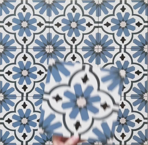 Vídeo de las baldosas porcelánicas Clarence Azul Blue 20x20 cm de estilo victoriano marroquí, destacando el intrincado patrón geométrico floral en azul y blanco y el acabado mate suave bajo luz natural.