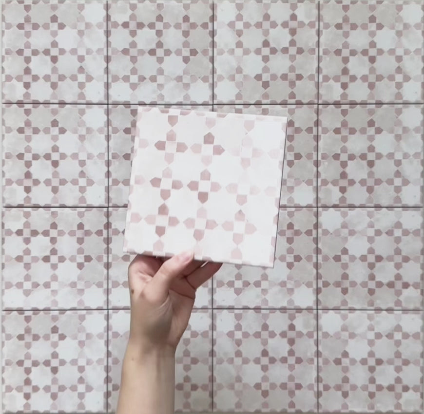 Vídeo del azulejo de estilo marroquí Bedouin Mequinez Rosa 15x15 cm, destacando su suave patrón geométrico de estrellas en rosa empolvado y blanco. El vídeo resalta el acabado mate artesanal, la variación tonal natural y el carácter decorativo desde diferentes ángulos bajo iluminación suave.