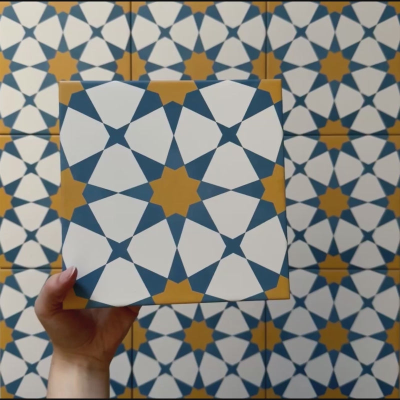 Vídeo de los azulejos cerámicos de estilo marroquí Agraba Sunshine 20x20 cm, resaltando su patrón geométrico de estrellas en azul, amarillo mostaza y blanco con acabado mate suave bajo luz natural.
